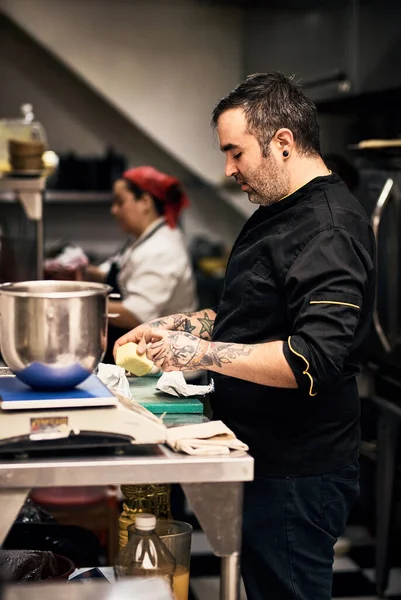 Allright lets get to work guys. Shot of a focused chef preparing a dish in the kitchen of a restaurant. —  Fotos de Stock