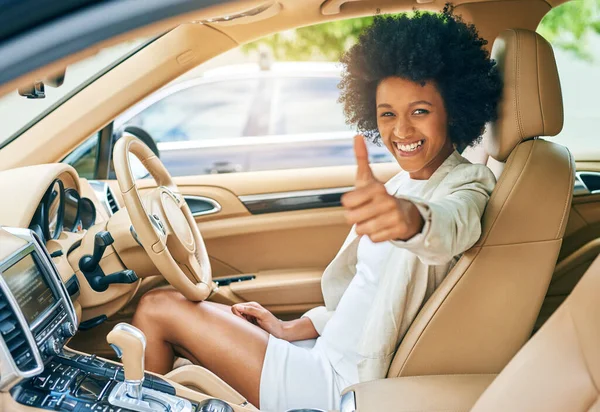 All systems go. Portrait of a cheerful young businesswoman driving in her car on her way to work while showing thumbs up to the camera during the day. — 스톡 사진