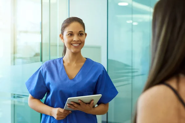 Saluto la sua paziente con un viso amico. Girato di una giovane infermiera amichevole che saluta un paziente in clinica. — Foto Stock