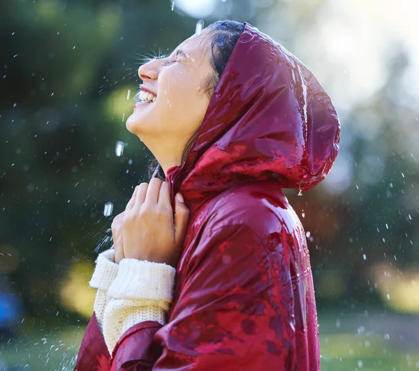 Todays a great day to enjoy life. Shot of a young woman enjoying the rain outside. Stock Image