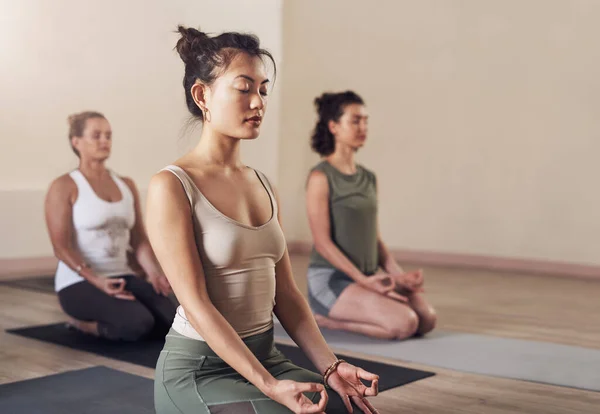 Meditação é um treino para a mente. Tiro de uma jovem mulher atraente meditando em uma aula de ioga. — Fotografia de Stock