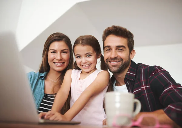 E 'pronta per una lezione di tecnologia wireless. Ritratto di una coppia sposata felice e della loro giovane figlia che usa un computer portatile insieme a casa. — Foto Stock