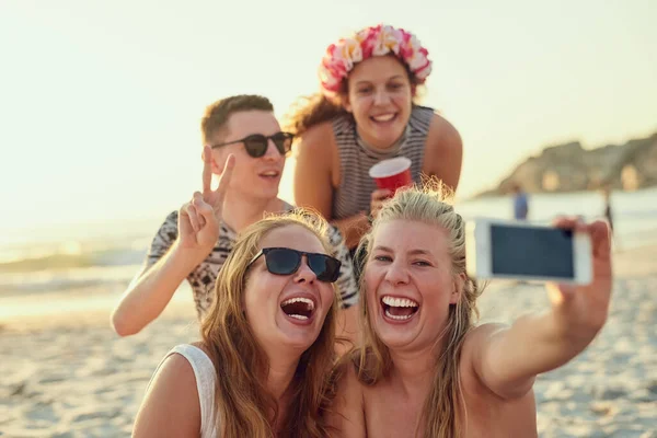 These photos are definitely. worth 1000 words. Shot of young people hanging out at the beach. — Stock Photo, Image