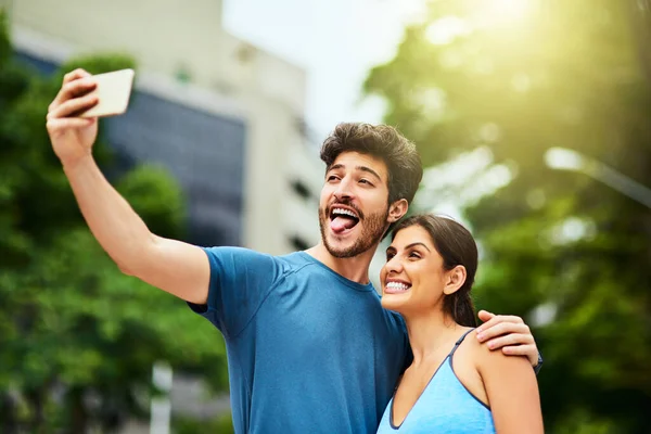 La forma fisica è la ragione del loro umore felice. Girato di una giovane coppia sportiva che si fa un selfie insieme all'aperto. — Foto Stock