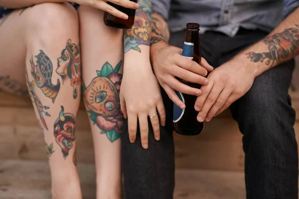 Tetování je další forma řeči těla. Vystřižená fotka páru s tetováním na těle a pitím v rukách. — Stock fotografie