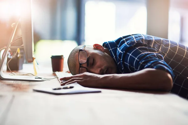 Sair do stress e adormecer. Tiro recortado de um jovem designer dormindo em sua mesa de escritório. — Fotografia de Stock