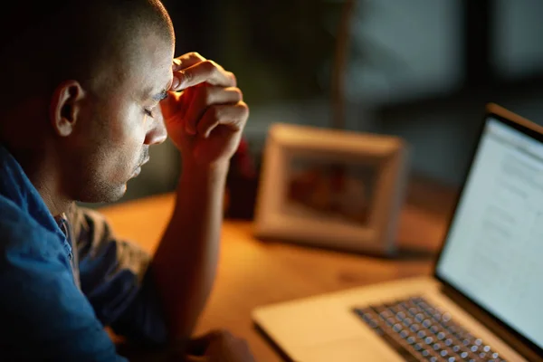 The long hours are getting to him. Cropped shot of a young businessman looking stressed out while working late in an office. —  Fotos de Stock