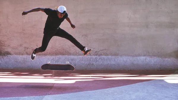 Tentez votre chance. Tourné d'un jeune homme faisant des tours sur son skateboard au skatepark. — Photo