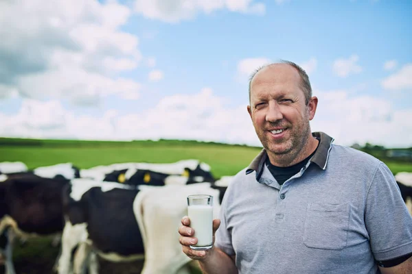 Je to jen to nejlepší na mé farmě. Oříznutý portrét farmáře stojícího se sklenicí mléka na mléčné farmě. — Stock fotografie