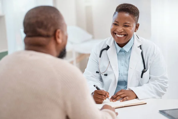 Haar toewijding en zorg brengt genezing en hoop. Opname van een jonge arts die aantekeningen schrijft tijdens een consult met een patiënt in een medisch kantoor. — Stockfoto