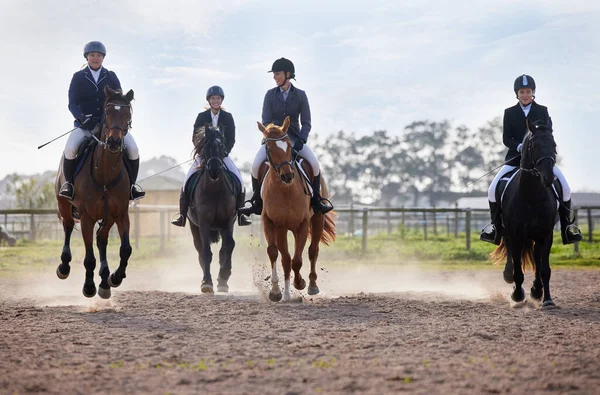 Theyre neck-and-neck. Full length shot of a group of attractive young female jockeys riding their horses out on the farm. — Stock Photo, Image