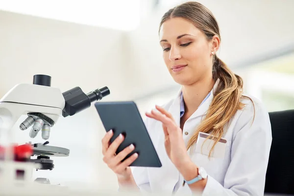 Technologie is een essentieel instrument voor elke onderzoeker. Gesneden opname van een jonge vrouwelijke wetenschapper die haar bevindingen vastlegt op een digitale tablet. — Stockfoto