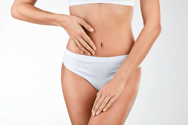 Een gezond darmmicrobioom behouden. Schot van een vrouw die haar maag aanraakt tegen een studio achtergrond. — Stockfoto