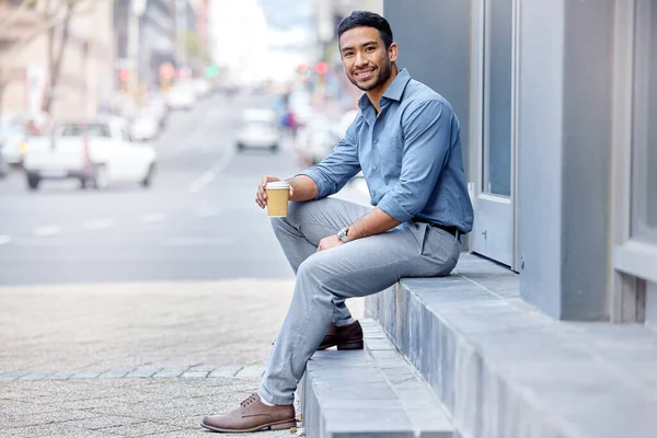In need of a coffee rush. Shot of a young businessman drinking a cup of coffee in the city. — Foto de Stock