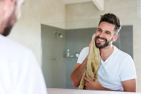 Kebersihan adalah di samping kesalehan. Foto seorang pemuda tampan yang sedang melalui adalah rutinitas pagi di kamar mandi. — Stok Foto