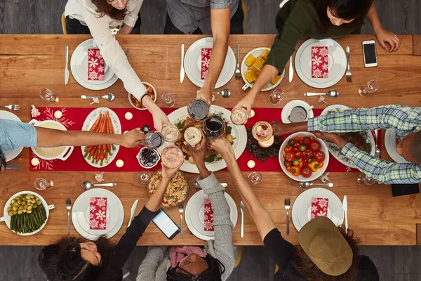 Food is best enjoyed with friends. Cropped shot of a group of people making a toast at a dining table. — Foto de Stock