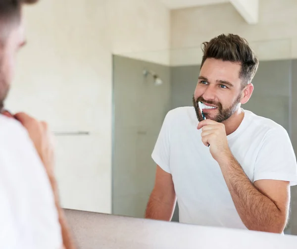 Sauberkeit steht neben Frömmigkeit. Schnappschuss eines hübschen jungen Mannes, der durchgeht, ist Morgenroutine im Badezimmer. — Stockfoto