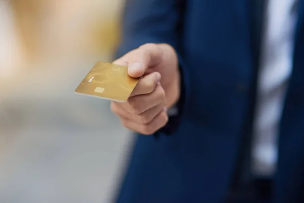 Paying by card. Cropped shot of an unrecognizable businessman holding out a credit card. — Photo