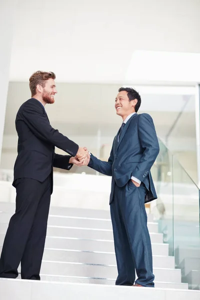 Another successful partnership. Shot of two businessmen shaking hands in a modern office. — стоковое фото