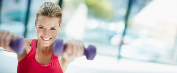 Im killing this workout. Cropped portrait of an attractive young woman working out with dumbbells. — Stock Photo, Image