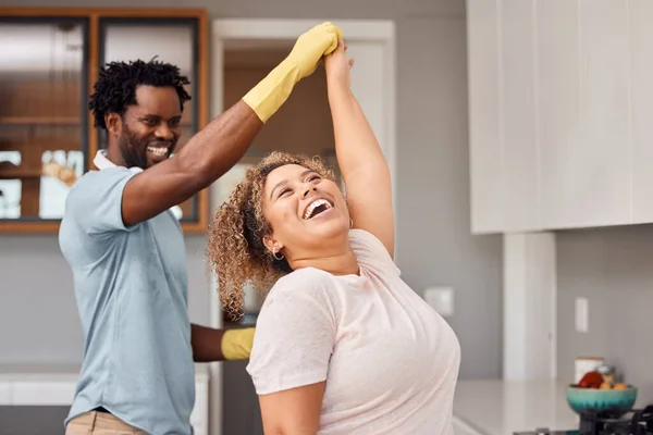 Its always a good time when we do chores together. Shot of a young couple dancing while cleaning at home. — Fotografia de Stock