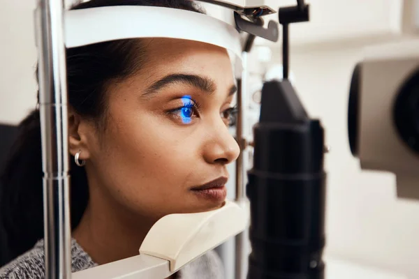 Fique o mais quieto possível. Tiro de uma jovem mulher examinando seus olhos com uma lâmpada de fenda. — Fotografia de Stock