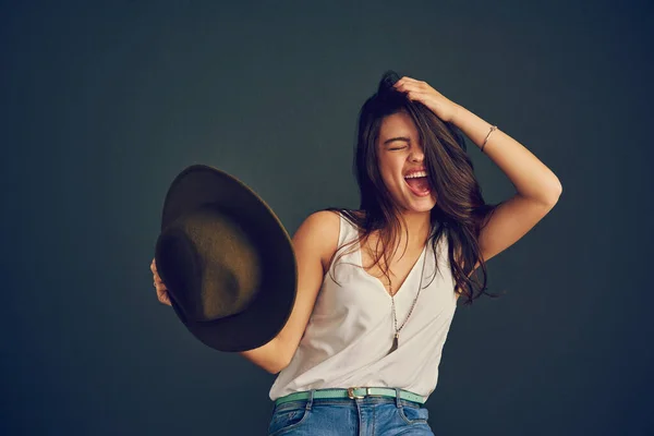 Mi tolgo il cappello da te. Studio girato di una giovane donna allegra che tiene la testa con una mano e tiene un cappello con l'altra. — Foto Stock