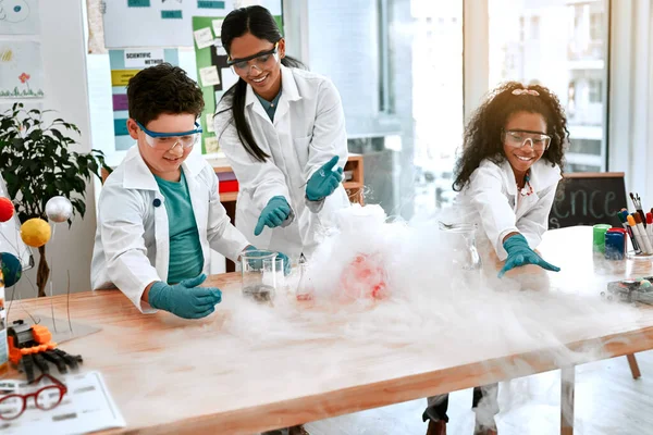 成長すればするほど探索することができます。学校で先生と科学実験をする可愛い男の子と女の子のショット. — ストック写真