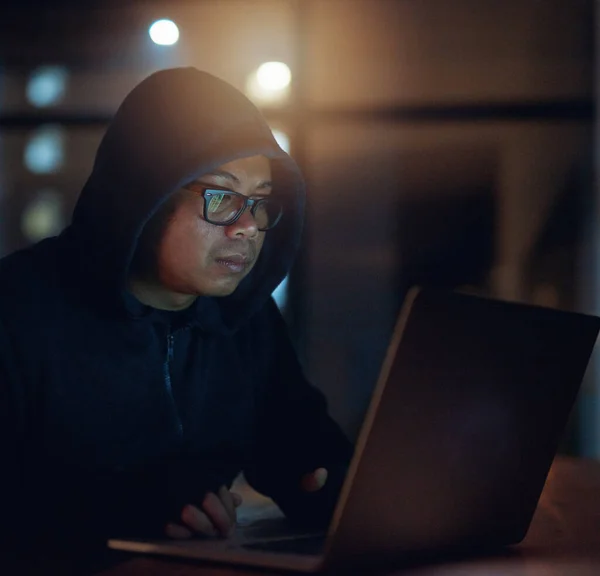 He can crack through any system. Shot of a hacker using a laptop in the dark. — Foto de Stock