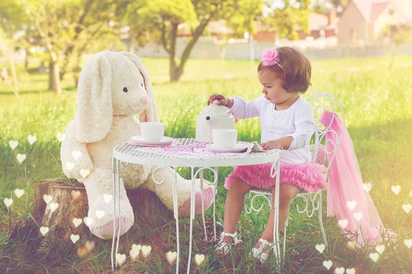 Some more tea, Mrs. Rabbit. Shot of a cute little girl having a tea party with her stuffed animal on the lawn outside. — ストック写真