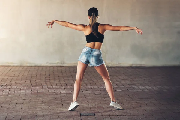 Ze krijgt haar groove terug. Achteraanzicht van een vrouwelijke straatdanseres aan het oefenen in de stad. — Stockfoto