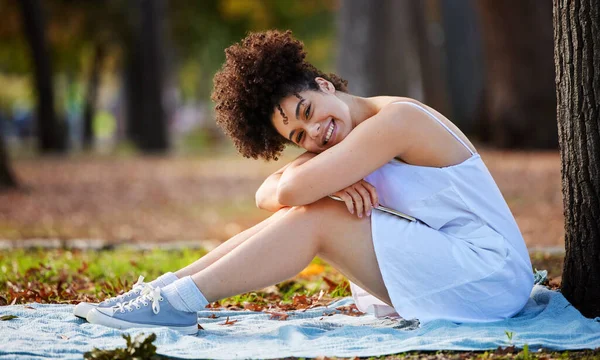 Happiness is... A day in the park. Full length portrait of an attractive young woman smiling happily while sitting in the park. — Photo