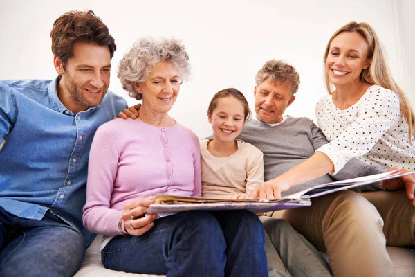Tohle je moje oblíbená fotka. Snímek šťastné vícegenerační rodiny při společném prohlížení fotoalba. — Stock fotografie