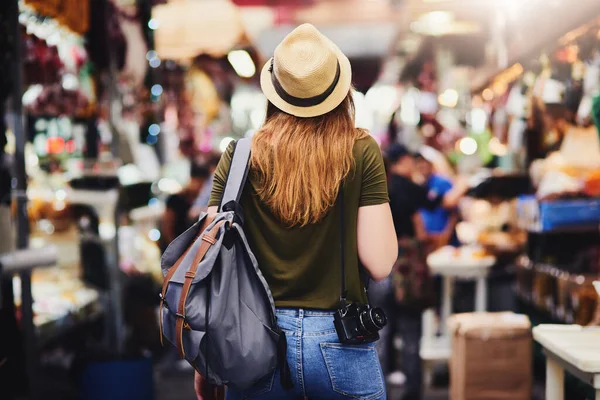 Moving on to the next area of wonder. Rearview shot of an unrecognizable woman wearing a hat and walking through a busy market outside during the day. — ストック写真