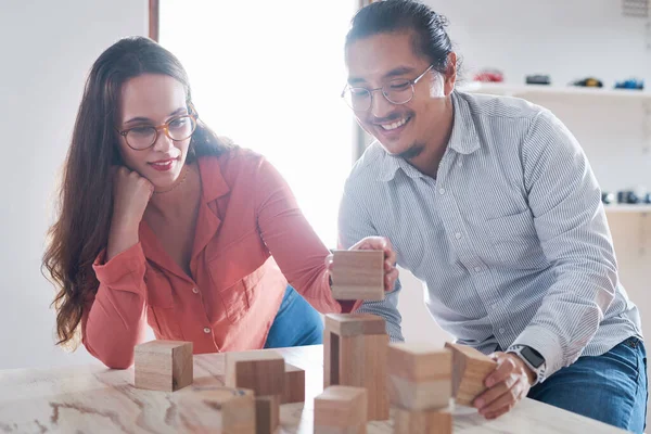 Niets drijft zo veel verandering als innovatie. Opname van een jonge zakenman en zakenvrouw die een ontmoeting hebben met bouwstenen in een modern kantoor. — Stockfoto