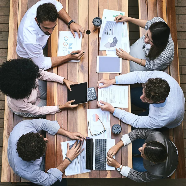 Teamwork and technology is all they need to succeed. High angle shot of a team of businesspeople having a meeting outside. — Stockfoto