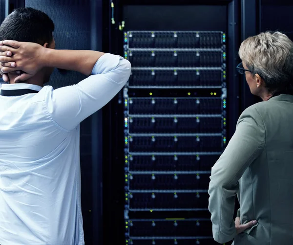 İyi bir IT gurusu tanıyan var mı? Bir veri merkezinde çalışan iki teknisyenin dikiz görüntüsü stresli görünüyor. — Stok fotoğraf