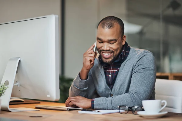 Catching up with some trusted clients over the phone. Shot of a handsome young businessman taking a phone call on his cellphone while working in his office. — Foto de Stock