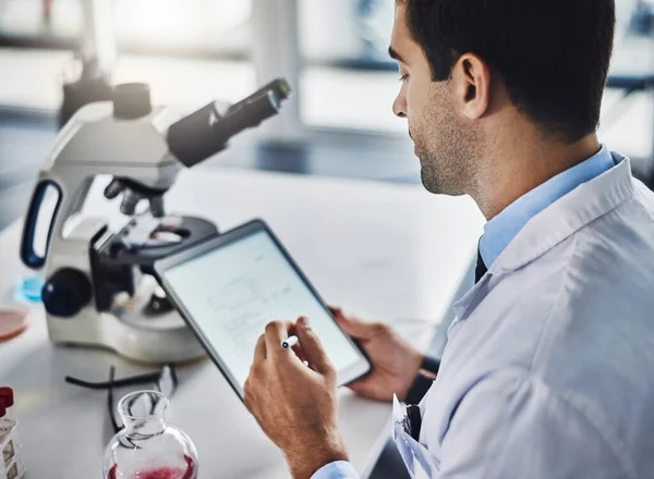 A registar novas descobertas. Tiro de um cientista usando um tablet digital enquanto trabalhava em um laboratório. — Fotografia de Stock