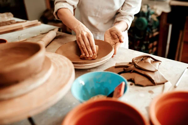 La esponja absorbe cualquier exceso de agua. Imagen recortada de un artesano irreconocible trabajando en un taller de cerámica. — Foto de Stock