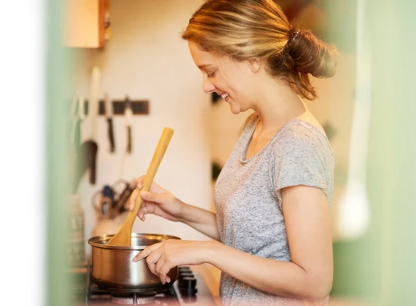 Lezzetli bir şeyler pişiriyorum. Çekici genç bir kadının evde yemek pişirirken görüntüsü.. — Stok fotoğraf