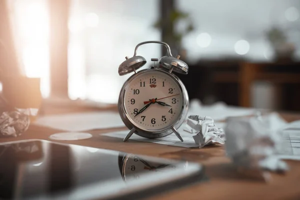 Zeit, diese sich abzeichnenden Fristen zu überstehen. Stillleben von einer Uhr und zerknülltem Papier auf einem Schreibtisch in einem Büro in der Nacht. — Stockfoto