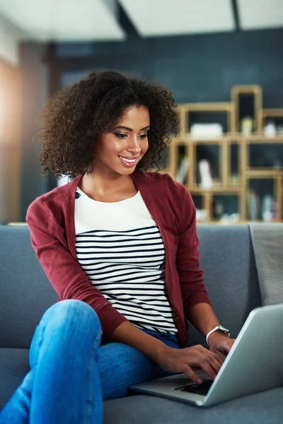 Er is elke dag iets nieuws om over te bloggen. Shot van een jonge vrouw met behulp van een laptop terwijl ontspannen op de bank thuis. — Stockfoto