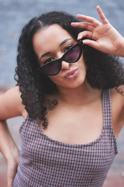 Jag slår vad om att du tycker att jag är cool. Skjuten av en ung kvinna i solglasögon när hon poserar utomhus. — Stockfoto