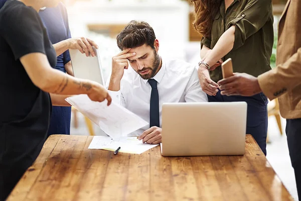 Sono davvero cosi 'stressata in questo momento. Colpo ritagliato di un uomo d'affari stressato circondato da colleghi che hanno bisogno di aiuto in un ufficio. — Foto Stock