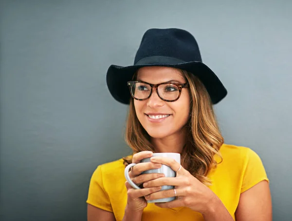 У нее есть свой собственный разум. Фотография молодой женщины, пьющей кофе на сером фоне. — стоковое фото