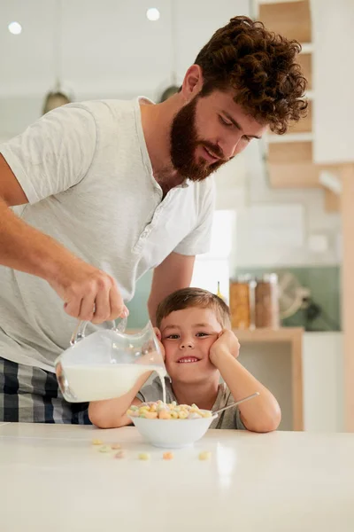 Le service par ici est excellent. Tourné d'un adorable petit garçon et son père prenant le petit déjeuner ensemble à la maison. — Photo