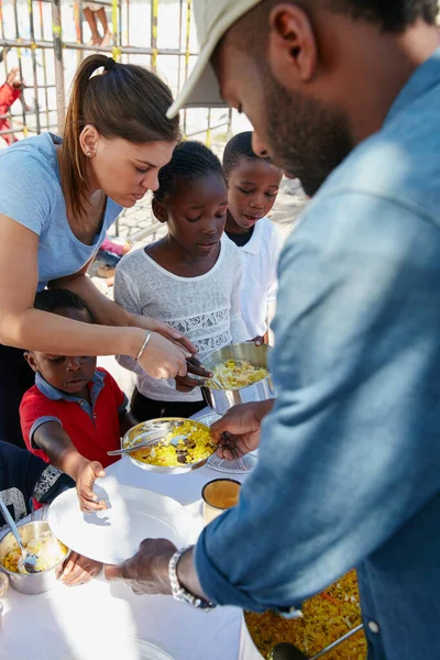 Aç ağızları beslemek. Bir gıda yardımında beslenen çocukların kırpılmış görüntüsü.. — Stok fotoğraf