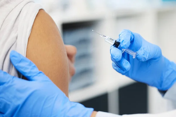 Outra vida salva. Tiro de um médico irreconhecível a injectar a vacina Covid na clínica.. — Fotografia de Stock
