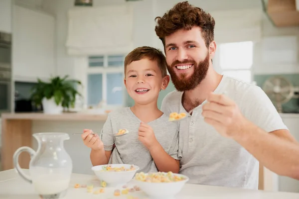 A reggelit jobb megosztani apával. Egy imádnivaló kisfiú és az apja együtt reggeliztek otthon.. — Stock Fotó